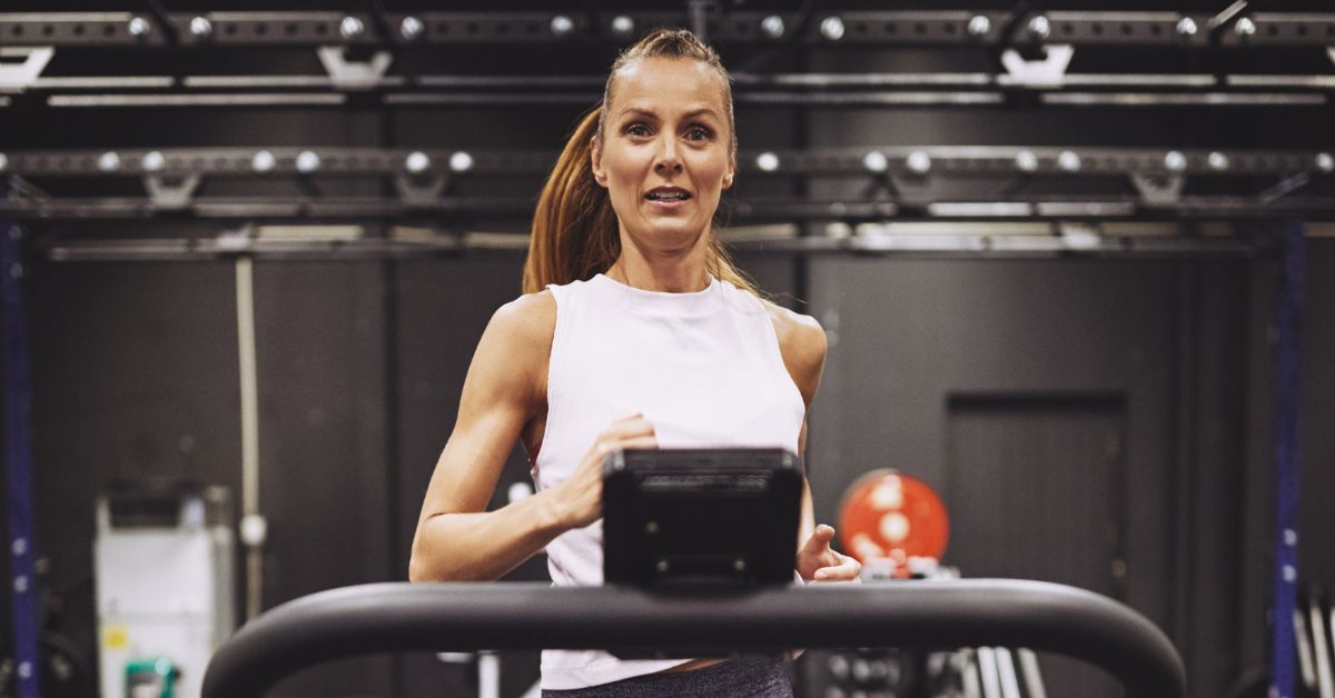 Kvinde som løber på løbebånd